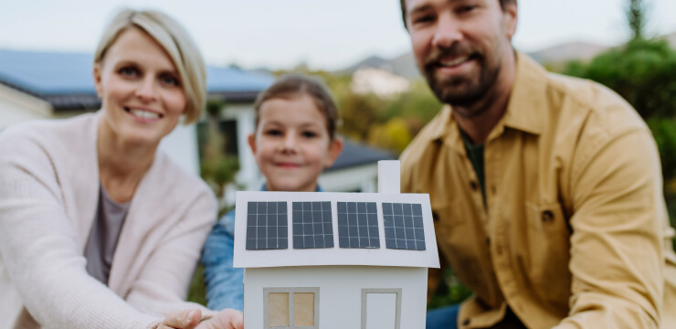 solar pro little girl with her dad holding paper model of house