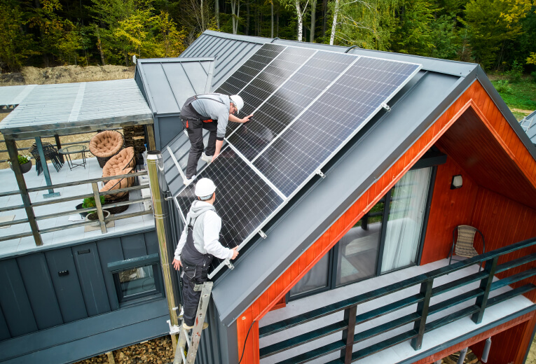 solar pro men workers installing solar panels on roof of house