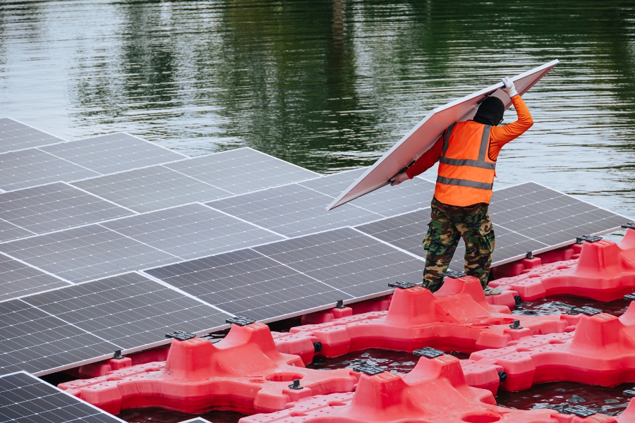 floating solar farm being built on water by a worker