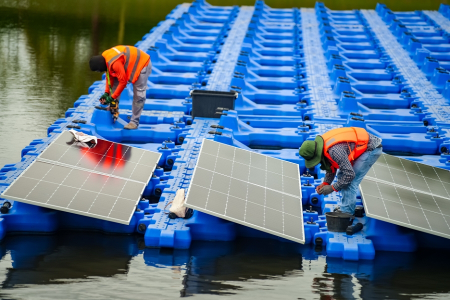 floating solar farm being built by two workers on water