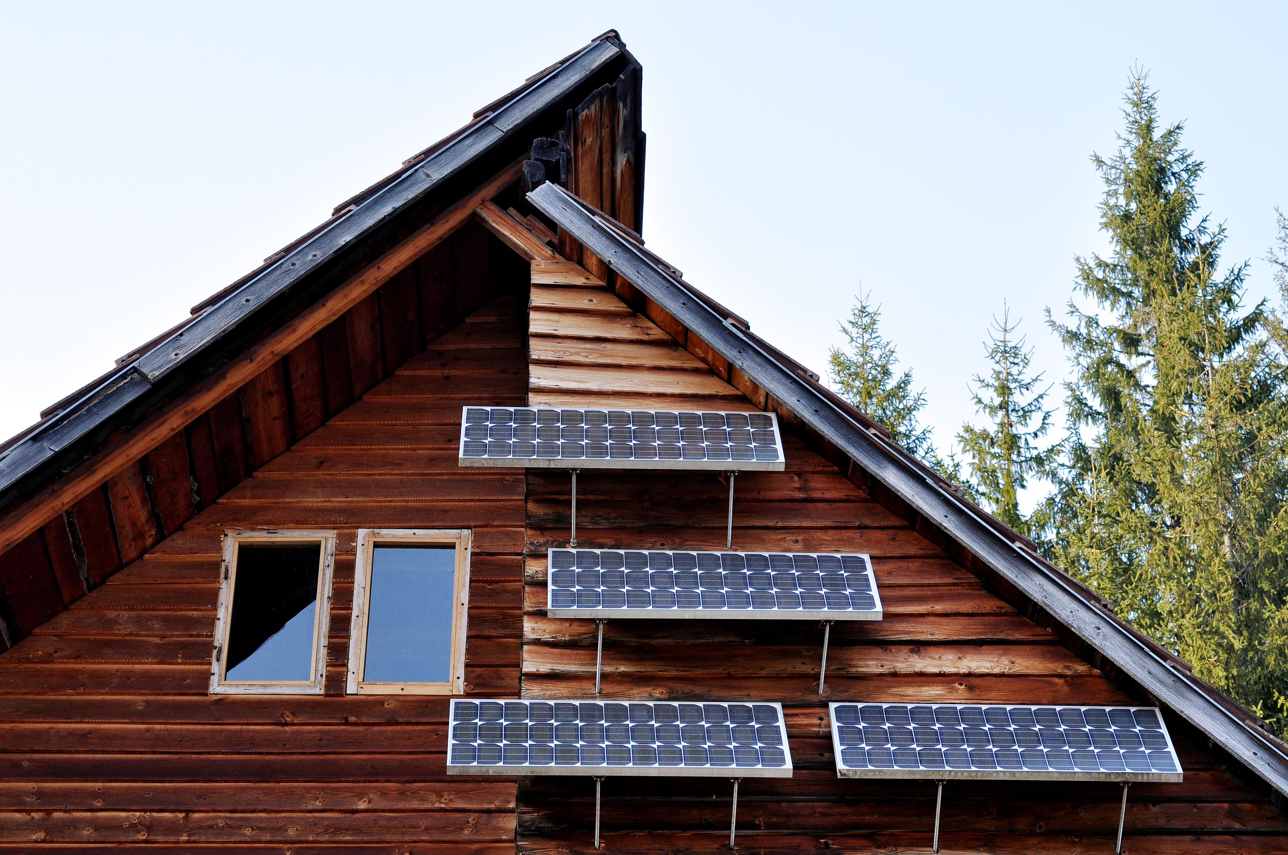 Solar panels on the ground in the nature off grid home with solar panels on the roof